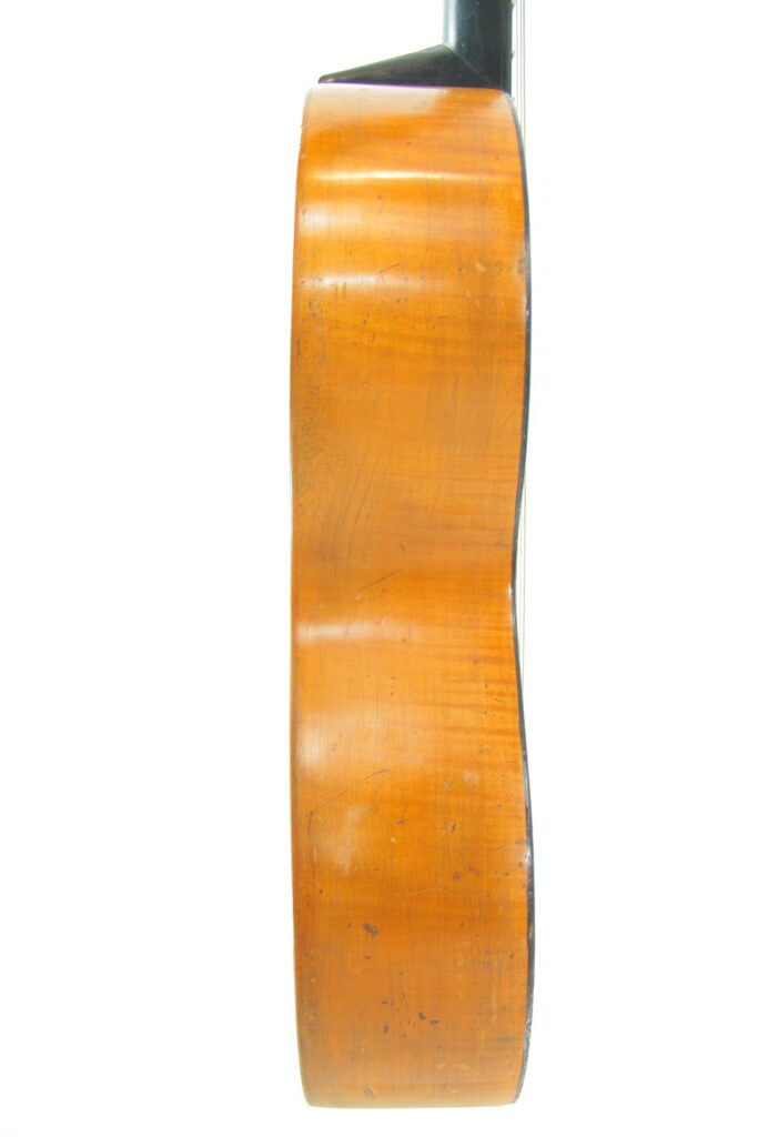 Seitenansicht Einer Französischen Romantikgitarre Von Ca. 1860, Die Ihren Eleganten Korpus Und Hals Aus Holz Vor Einem Weißen Hintergrund Hervorhebt.