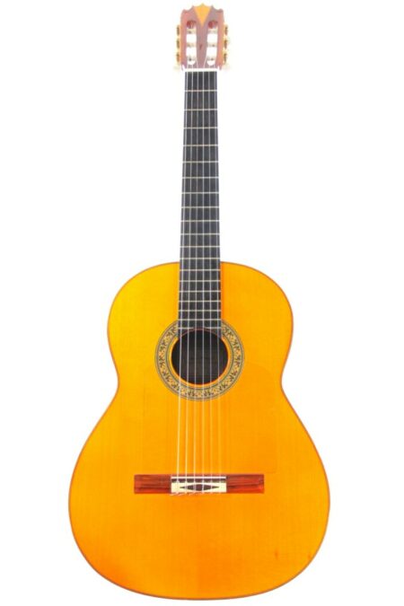 The Jose Romero 1996 Flamenco Guitar features a light brown body, six strings, black fretboard, and decorative sound hole inlays, shown against a white background.