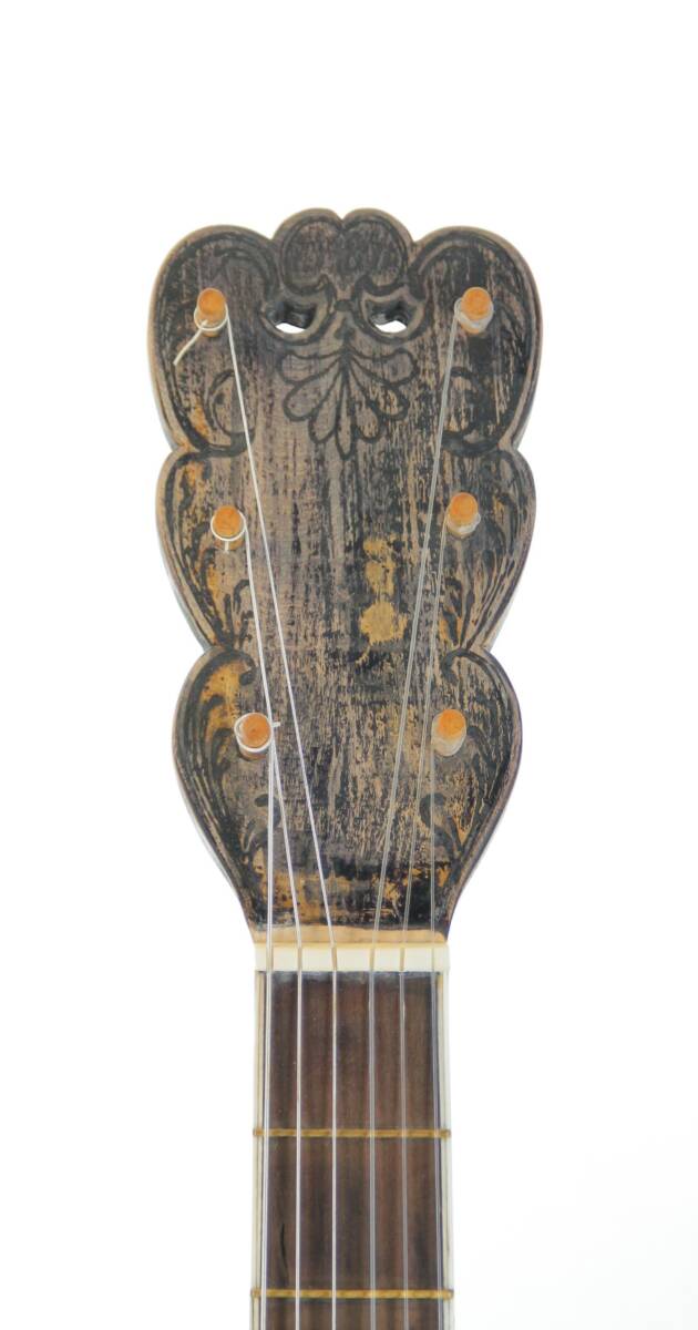 Close-Up Of A Worn, Ornately Carved Karl Frey Baroque Guitar Headstock Featuring Six Tuning Pegs And Visible Strings, Set Against A White Background.