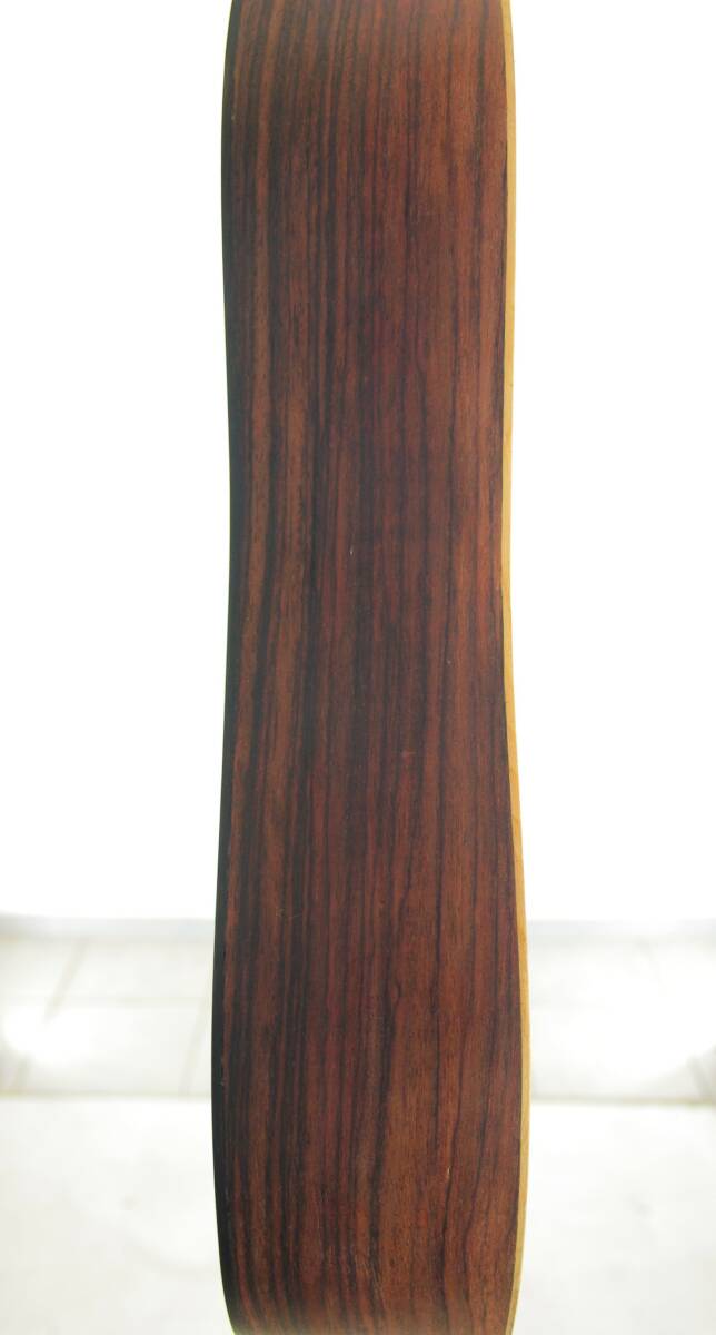 Close-Up Side View Of The Luis Milan Vihuela 1535/36, Highlighting Its Wood Grain And Smooth Finish Against A White Background.