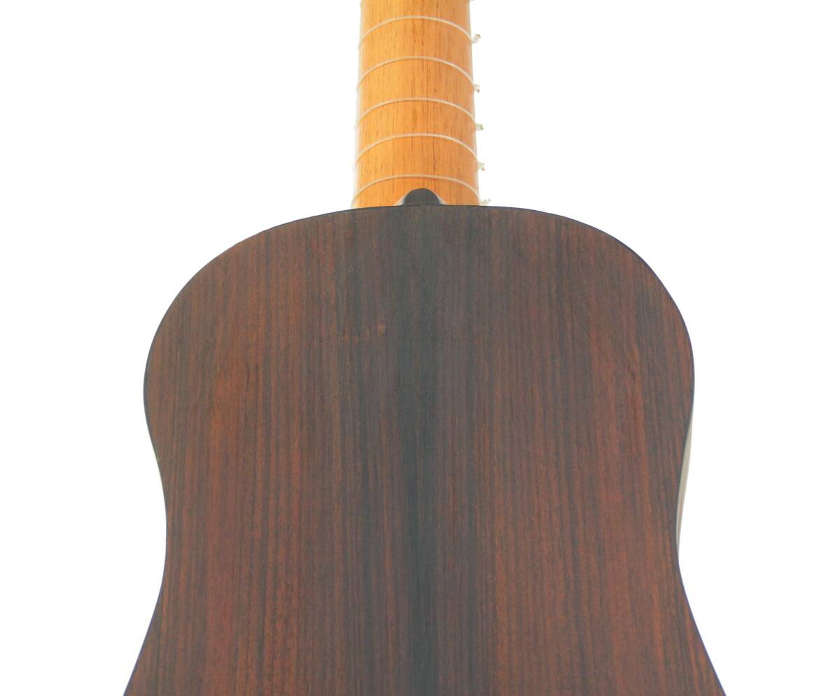 Close-Up Of The Back Of The Luis Milan Vihuela 1535/36, Featuring Its Dark Wood Grain Body And Lighter Neck With Visible Frets. The Rear View Highlights The Instruments Smooth Finish And Elegant Craftsmanship.
