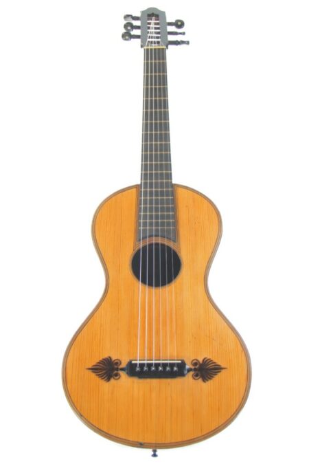 The Joseph Kriner 1865 Romantic Guitar features a light wooden body, dark fretboard, six strings, and decorative floral patterns near the bridge. It is photographed against a white background.