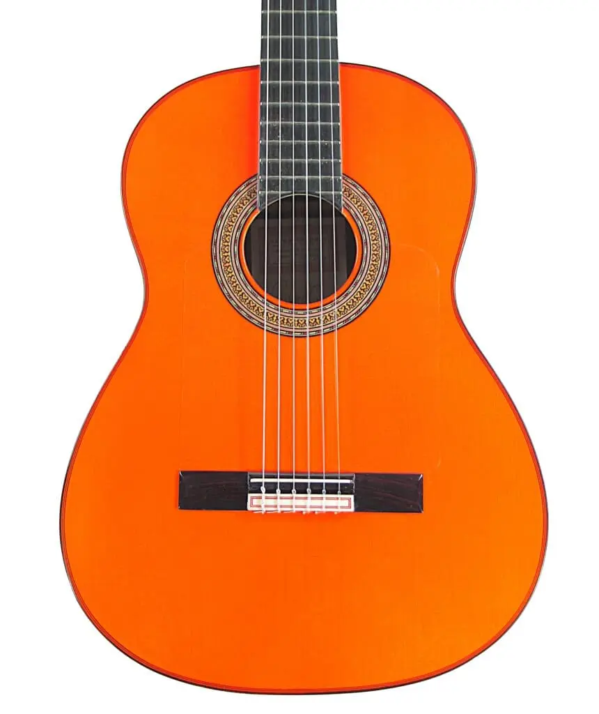 Eine Nahaufnahme Der Hermanos Conde 1999 Paco De Lucia Spezial Flamenco Gitarre Zeigt Den Orangefarbenen Korpus, Die Saiten, Die Zierrosette Um Das Schallloch Und Einen Teil Des Halses Vor Einem Weißen Hintergrund.