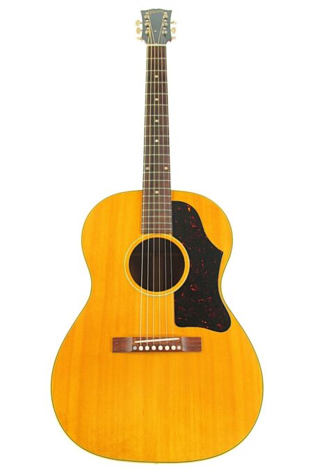 A 1957 Gibson LG-3 acoustic guitar with a natural wood finish, dark pickguard, six strings, and dot fretboard inlays seen from the front.