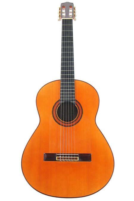 A Lorenzo Alvarez 1976 Flamenco Guitar is displayed upright against a white background, featuring a wooden body, six strings, a dark fingerboard, and a circular sound hole.