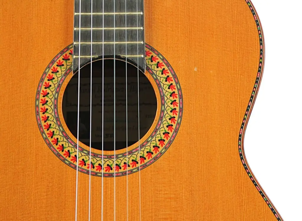 Nahaufnahme Der Manuel Rodriguez Jr Klassischen Gitarre Mit Fokus Auf Ihrem Schallloch Mit Einer Lebendigen Rosette, Dem Detaillierten Griffbrett Und Den Saiten Sowie Der Wunderschönen Holzmaserung Ihres Korpus.