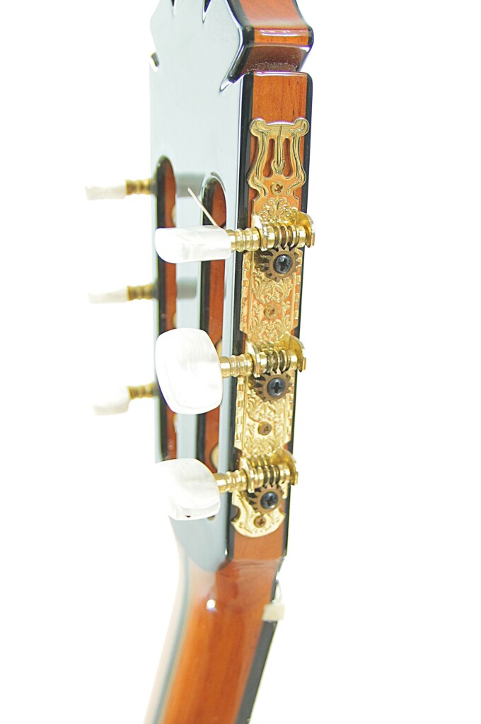 Nahaufnahme Der Stimmwirbel Und Der Kopfplatte Der Manuel Rodriguez Jr Klassischen Gitarre Mit Kunstvollen Goldfarbenen Metallarbeiten Und Weißen Stimmschlüsseln Vor Einem Weißen Hintergrund.