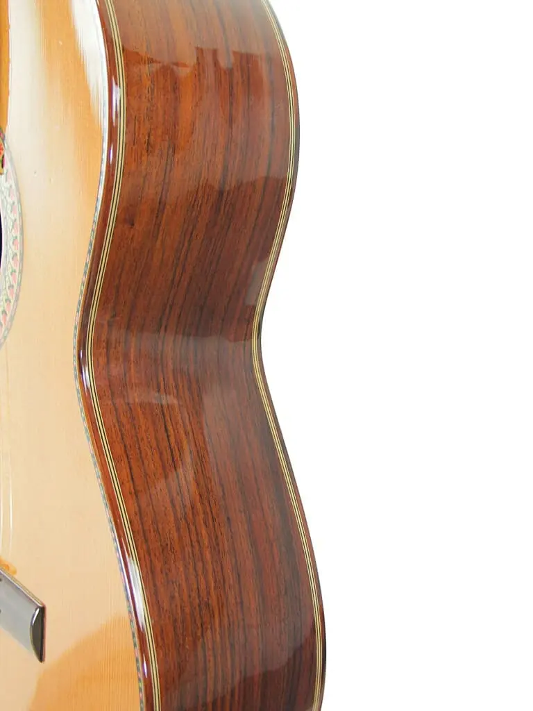 Nahaufnahme Der Manuel Rodriguez Jr Klassischen Gitarre Mit Ihrem Glänzenden Holzkorpus Mit Sichtbarer Maserung, Fotografiert Vor Einem Schlichten Weißen Hintergrund.