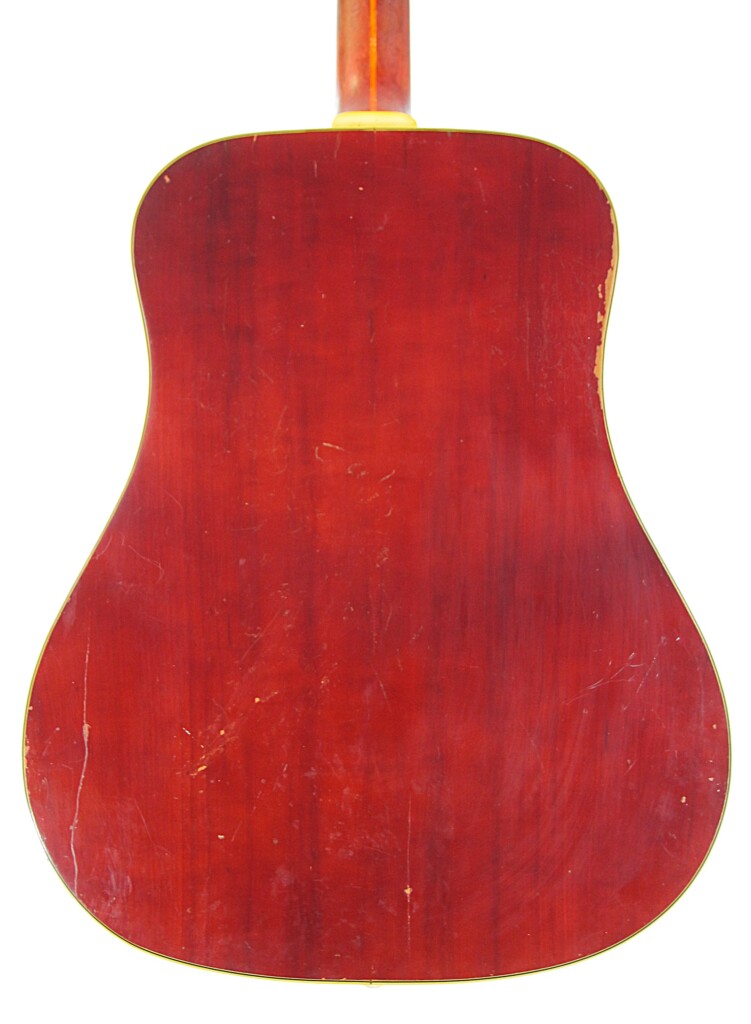 The Back Of The Guild D-44 1967 Acoustic Guitar Features Glossy Red Wood With Visible Scratches And Worn Edges.