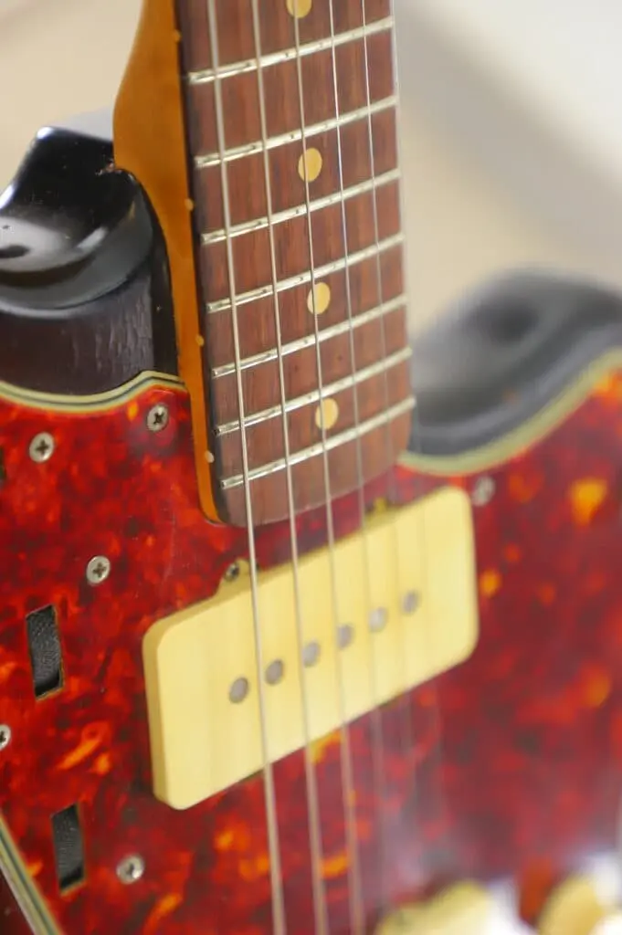 Close-Up Of The Fender Jazzmaster 1963 Electric Guitar, Featuring Its Neck, Frets, Strings, Red Tortoiseshell Pickguard, And Cream-Colored Pickup.