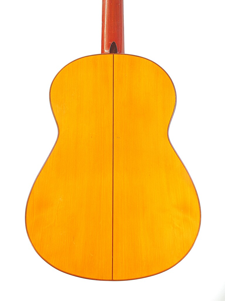 The Image Shows The Back Of A Hermanos Conde 1966 Faustino Conde Flamenco Guitar With A Glossy Wooden Finish, A Vertical Center Seam, And A Light Golden-Brown Body.