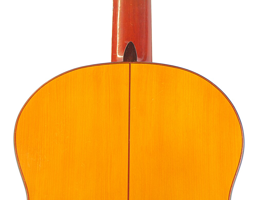 Close-Up Of The Back Of A Hermanos Conde 1966 Faustino Conde Flamenco Guitar, Highlighting Its Smooth, Polished Light Wood With A Central Seam And Part Of The Neck Visible At The Top.
