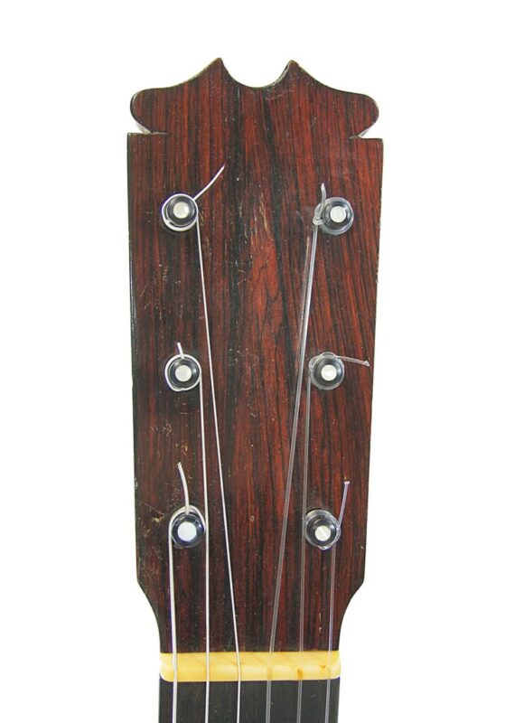 Close-up of the headstock on a Hermanos Conde 1966 Faustino Conde Flamenco Guitar, featuring tuning pegs and some loosely attached metal strings. The dark wood grain and distinctive top design are clearly visible.