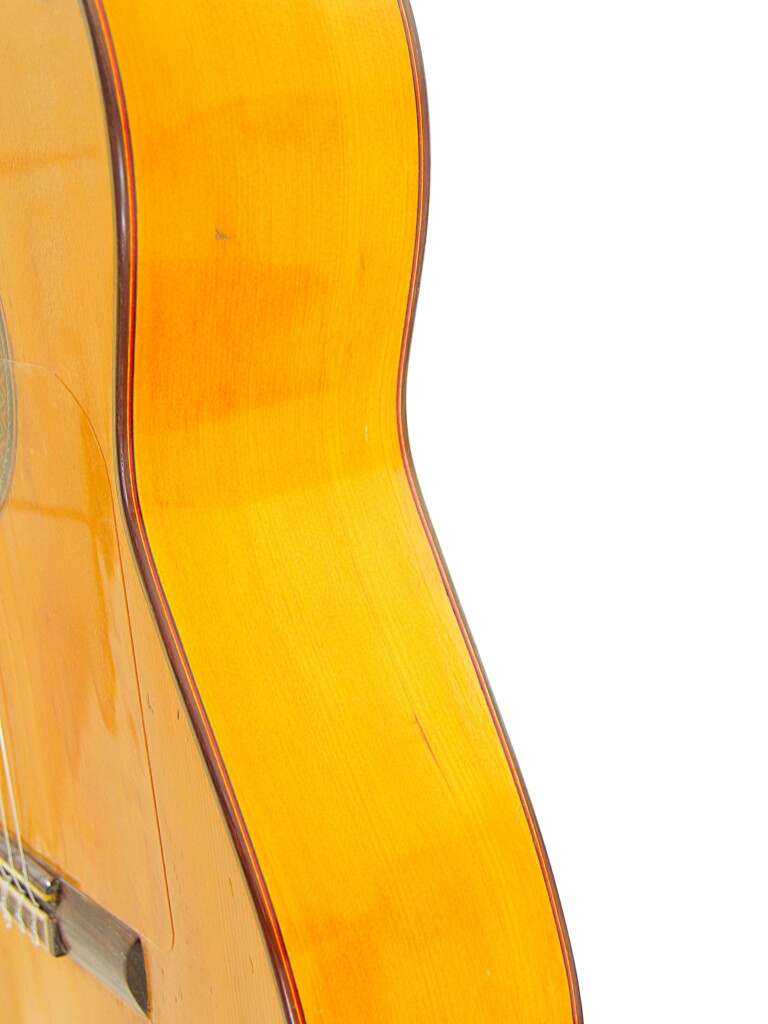 Close-Up Of The Side And Partial Front Of A Hermanos Conde 1966 Faustino Conde Flamenco Guitar With A Glossy Light Wood Finish, Set Against A Plain White Background.