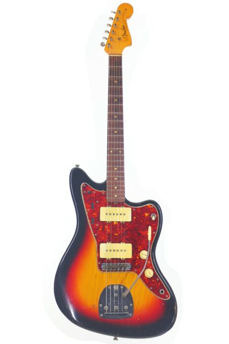 A front view of the Fender Jazzmaster 1963 Electric Guitar featuring a sunburst finish, white pickups, red tortoiseshell pickguard, and maple neck against a white background.