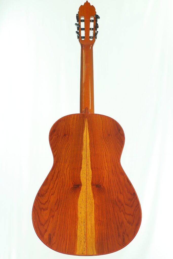 Rückansicht einer Flamenco-Gitarre von Gerardo Escobedo aus dem Jahr 2018 mit einem Korpus in Holzmaserung und einem hellen Mittelstreifen. Rückansicht einer Flamenco-Gitarre von Gerardo Escobedo aus dem Jahr 2018 mit einem Korpus in Holzmaserung und einem hellen Mittelstreifen.