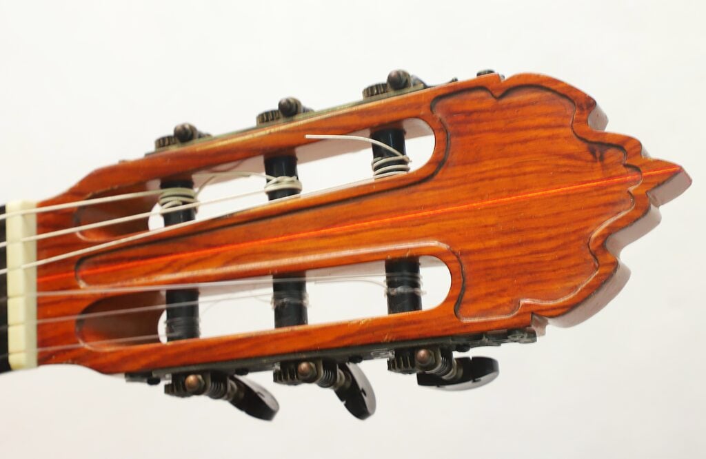 Nahaufnahme des Kopfes einer Flamenco-Gitarre von Gerardo Escobedo aus dem Jahr 2018 mit Stimmwirbeln und Saiten. Nahaufnahme des Kopfes einer Flamenco-Gitarre von Gerardo Escobedo aus dem Jahr 2018 mit Stimmwirbeln und Saiten.