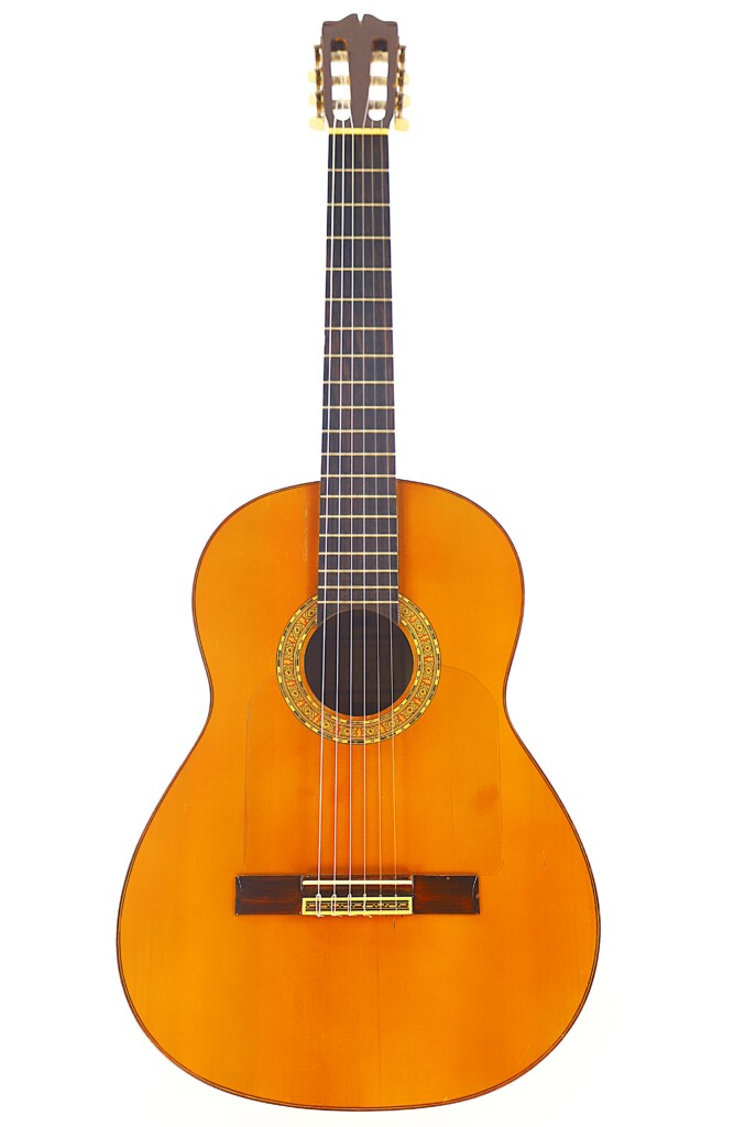The Manuel G. Mayoral 1980 Flamenco Guitar Features A Light Brown Wooden Body, Dark Fingerboard, Six Strings, And A Decorative Rosette Around The Sound Hole, Displayed Against A White Background.