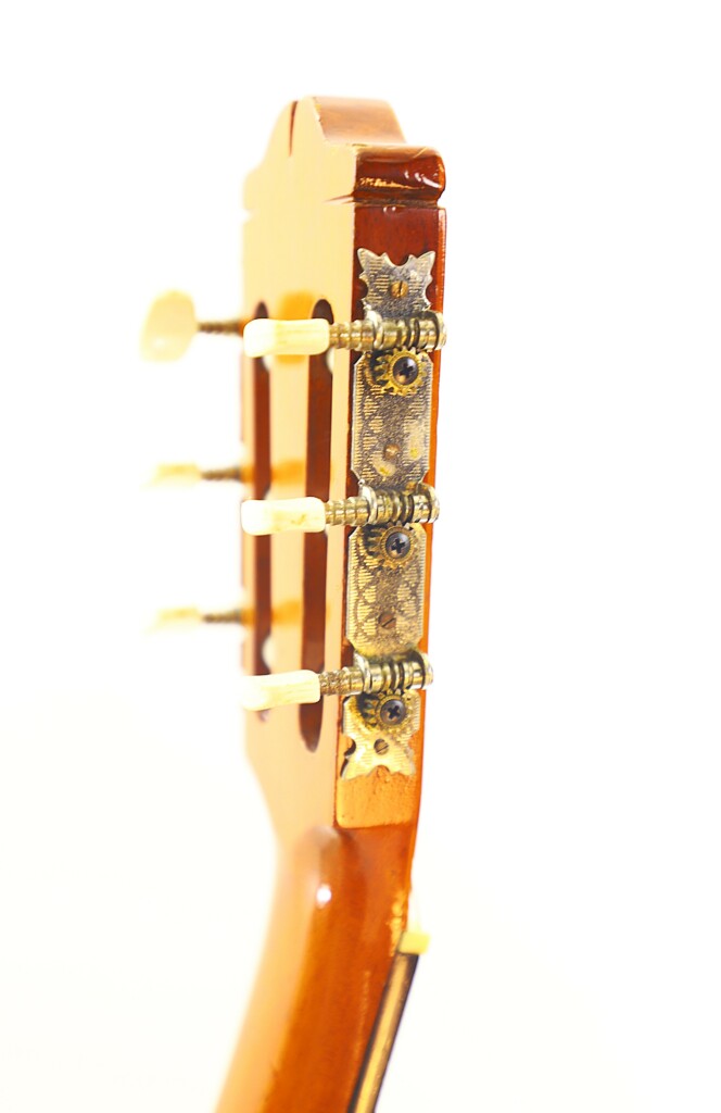 Close-Up Of The Manuel G. Mayoral 1980 Flamenco Guitars Headstock, Featuring Three White Tuning Keys And An Ornate Metal Tuning Plate Against A White Background.