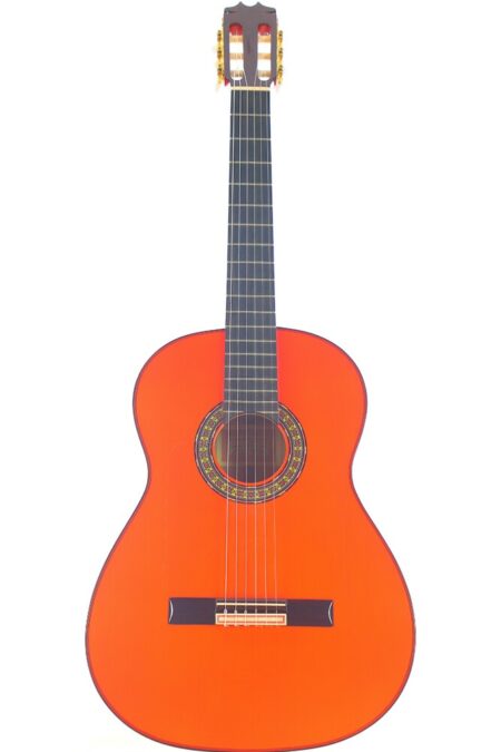The Hermanos Conde 1990 Blanca Flamenco Guitar features a bright orange body, dark fretboard, and decorative rosette around the sound hole, shown upright against a white background.