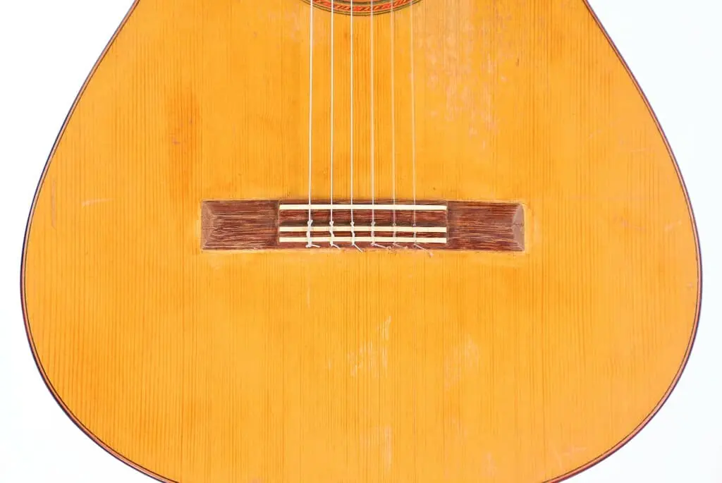 Close-Up Of The Marcelino López Nieto 1954 Flamenco Guitar, Highlighting Its Six Strings, Wooden Bridge, And Light-Colored Wooden Finish.