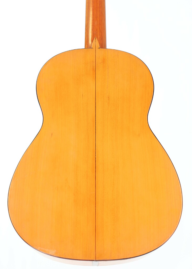 Back View Of The Marcelino López Nieto 1954 Flamenco Guitar, Featuring A Smooth, Polished Wood Surface With A Visible Center Seam, Displayed Against A White Background.