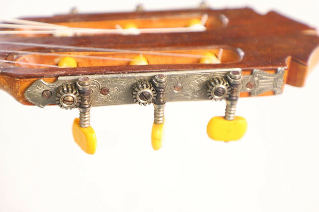 Close-Up Of The Marcelino López Nieto 1954 Flamenco Guitar Headstock, Featuring Three Yellow Tuning Pegs, Metal Gears, And Strings Set Against A White Background.