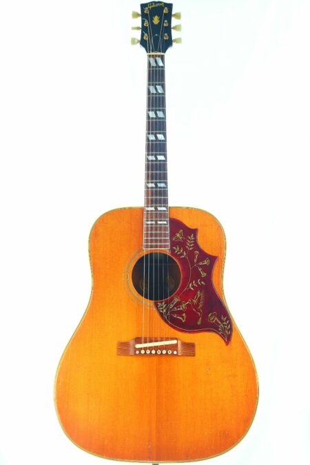 The Gibson Hummingbird 1966 Acoustic Guitar features a vintage natural wood finish, a red floral pickguard, pearl fretboard inlays, and displays the Gibson logo on the headstock.