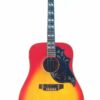 Eine Gibson Hummingbird 1966 Akustik Gitarre mit Sonnenschliff, dekorativem Schlagbrett und eingelegten Bundmarkierungen, fotografiert vor weißem Hintergrund. Eine Gibson Hummingbird 1966 Akustik Gitarre mit Sonnenschliff, dekorativem Schlagbrett und eingelegten Bundmarkierungen, fotografiert vor weißem Hintergrund.