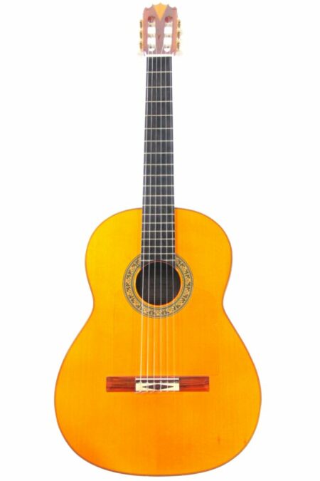 The Jose Romero 1996 Flamenco Guitar features a wooden body, six strings, a rosette around the sound hole, and a slotted headstock, displayed against a white background.