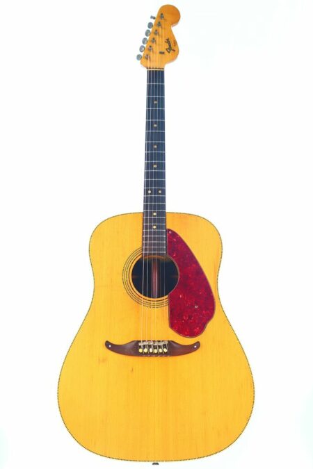 The Fender King 1963 Acoustic Guitar features a vintage style with a light wood body, dark wood bridge, red tortoiseshell pickguard, and distinctive headstock with tuning pegs, shown against a white background.