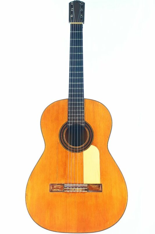 Die Santos Hernandez 1916 Konzertgitarre verfügt über ein Naturholzfinish, ein dunkles Griffbrett, sechs Saiten und eine dekorative Rosette um das Schallloch, die vor einem weißen Hintergrund fotografiert ist.