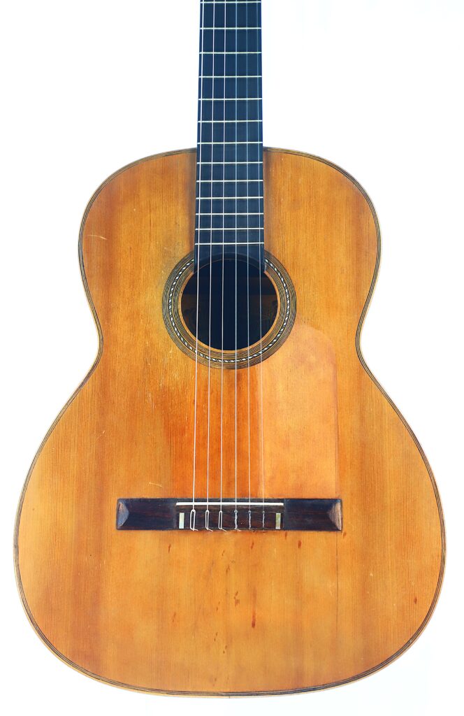 The Salvador Ibanez ~1900 Classical Guitar Features A Wooden Body, Six Strings, And A Round Sound Hole, Shown Against A White Background.