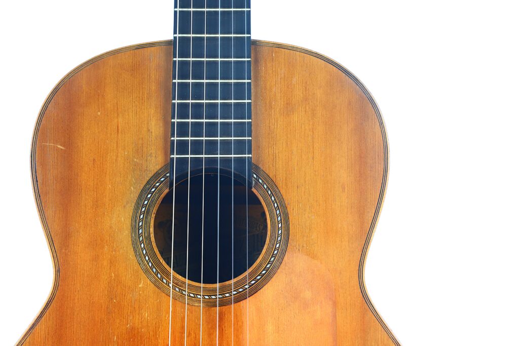 Close-Up Of The Body And Neck Of A Salvador Ibanez ~1900 Classical Guitar With A Wooden Finish, Isolated On A White Background.