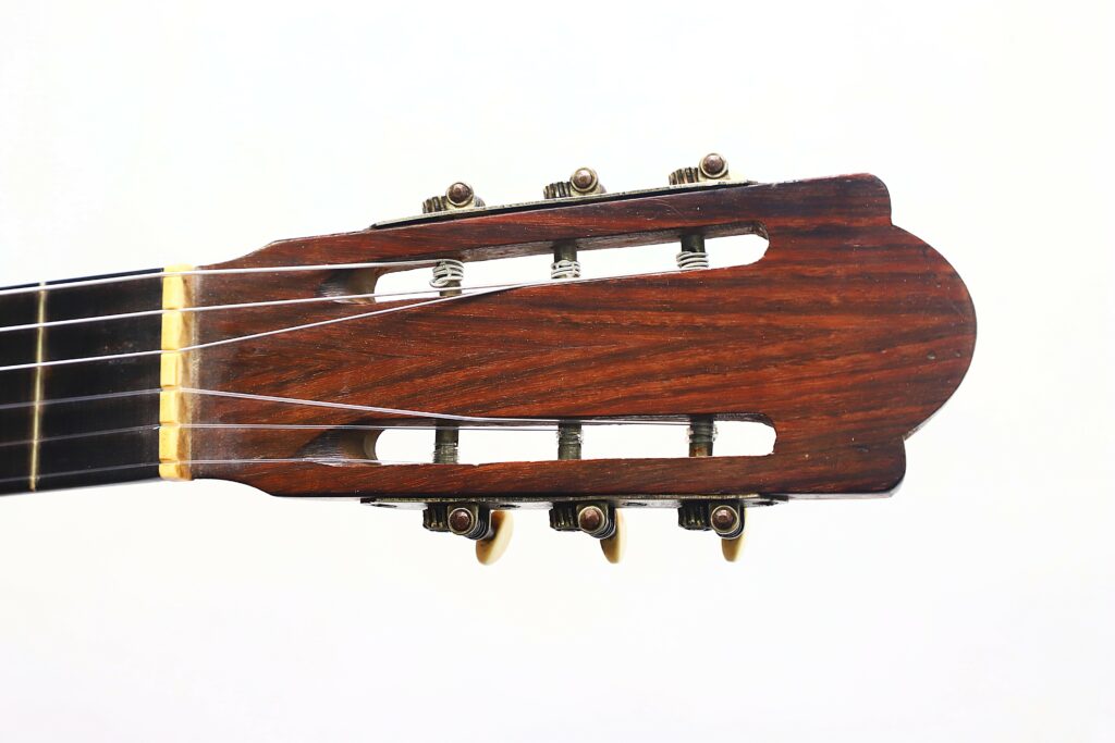 Close-Up Of The Headstock Of A Salvador Ibanez ~1900 Classical Guitar Showing Tuning Pegs, Posts, And Strings Against A Plain White Background.