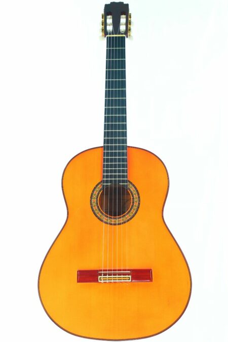 The Rafael Romero 2005 Flamenco Guitar features a light brown wooden body, dark fretboard, six strings, and a decorated sound hole, shown against a plain white background.