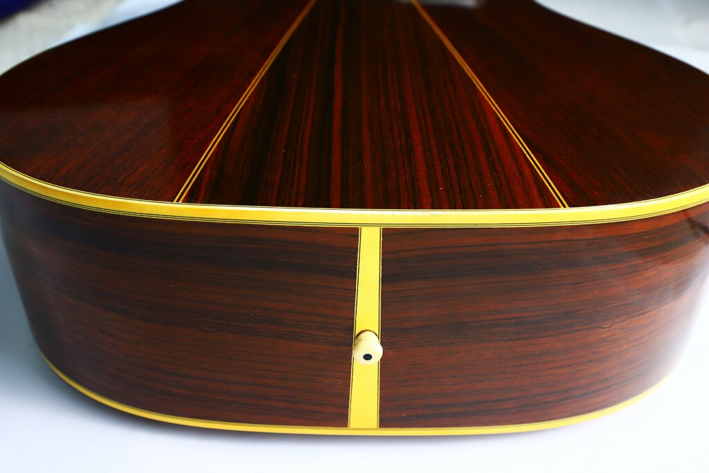 Close-Up Of The Back And Sides Of A Martin D-35 1979 Acoustic Guitar, Featuring A Rich Dark Wood Finish, Yellow Trim, And A Single Strap Button Centered At The Bottom Edge.