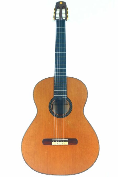 The Arturo Sanzano 1998 Classical Guitar features a wooden body, dark fingerboard, nylon strings, and gold tuning pegs, shown on a white background.