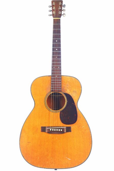 A 1954 Martin 00-18 acoustic guitar with a natural wood finish, dark pickguard, six strings, and visible body wear is photographed against a white background.