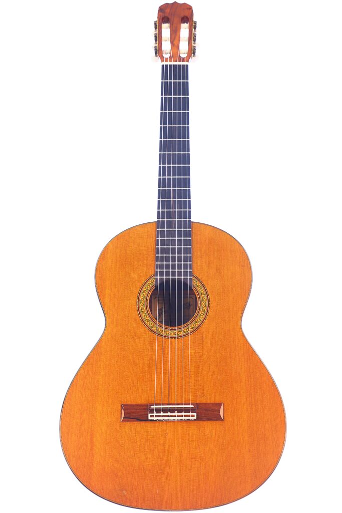 The Jose Ramirez 1A 1975 Classical Guitar Features A Wooden Body, Dark Fretboard, And Intricate Decorative Rosette Around The Sound Hole, Displayed Against A White Background.