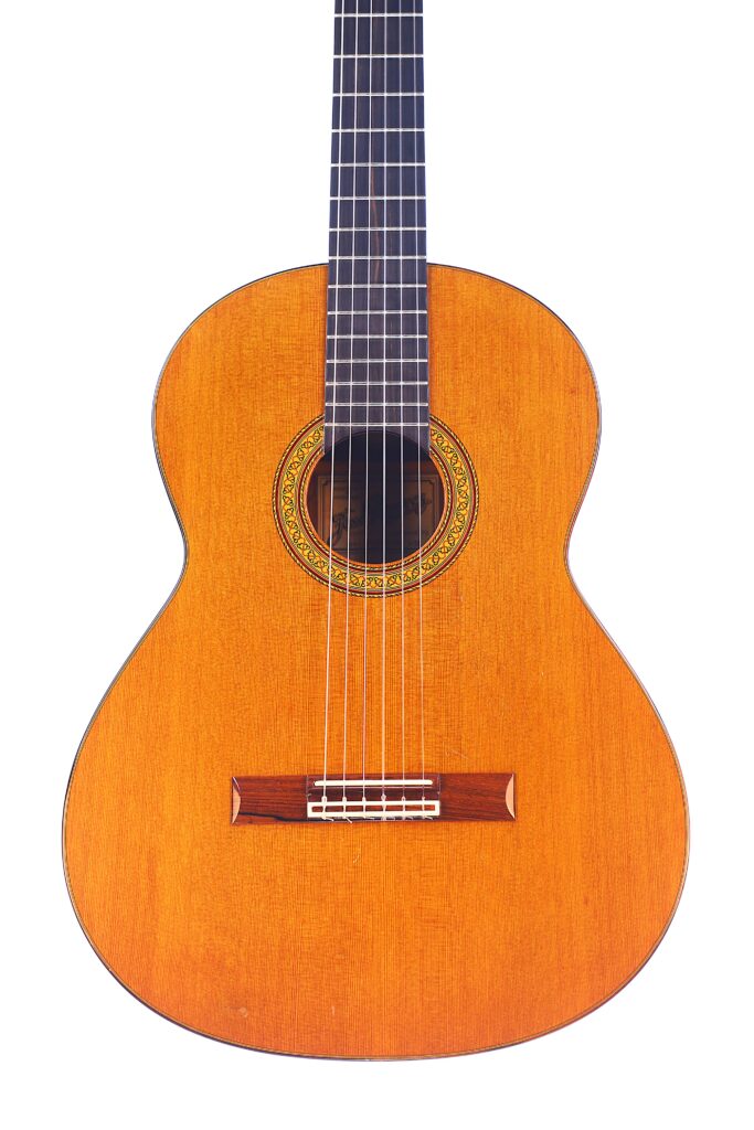The Jose Ramirez 1A 1975 Classical Guitar Features A Natural Wood Finish, Six Strings, A Decorative Soundhole Rosette, And A Wooden Bridge, Displayed Against A White Background.