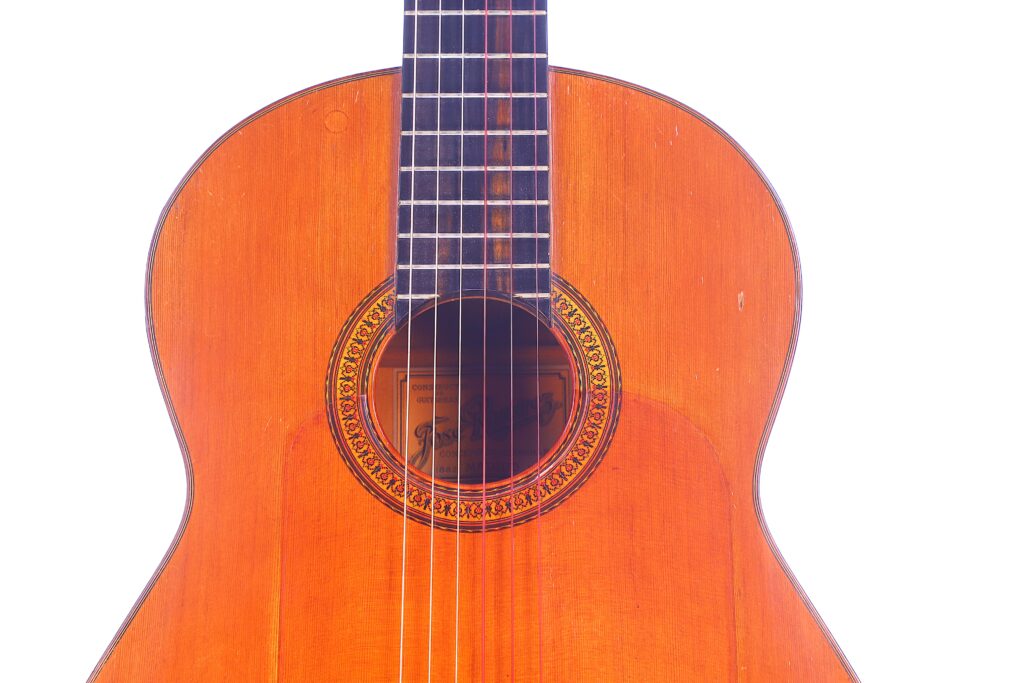 Close-Up Of The Body And Neck Of A Jose Ramirez 1968 Flamenco Guitar, Featuring Six Strings, A Wooden Sound Hole With Decorative Inlay, And A Glossy Light Brown Finish Against A White Background.