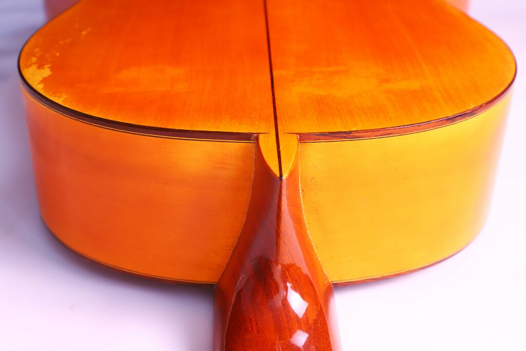 Close-Up Of The Back And Neck Joint Of A Jose Ramirez 1968 Flamenco Guitar, Featuring Polished Warm Golden-Brown Wood And Subtle Wear Marks Near The Top Edge.