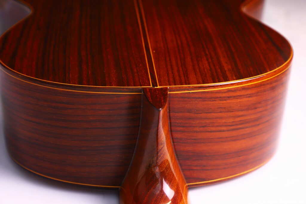 Close-Up Of The Back And Neck Joint Of A Jose Ramirez 1A 1975 Classical Guitar, Highlighting Its Smooth, Polished Wood Grain, Glossy Finish, And Finely Detailed Edges.