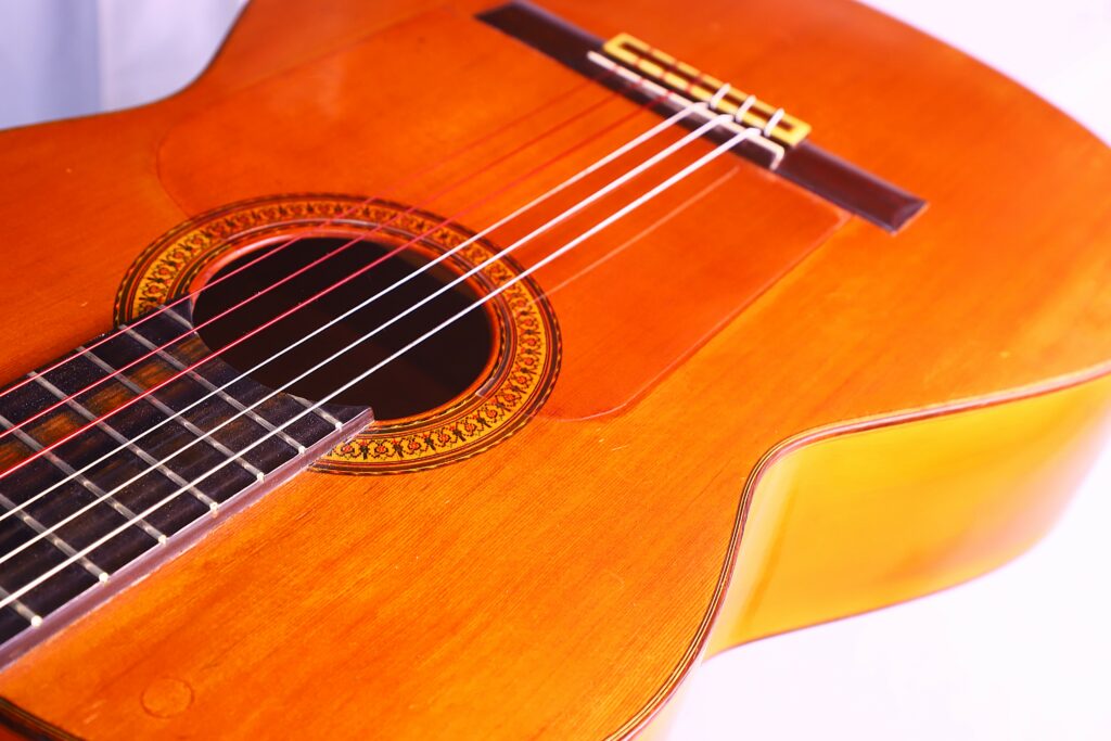 Close-Up Of A Jose Ramirez 1968 Flamenco Guitar, Highlighting Its Strings, Sound Hole With Decorative Rosette, And Wooden Body Under Bright Lighting.