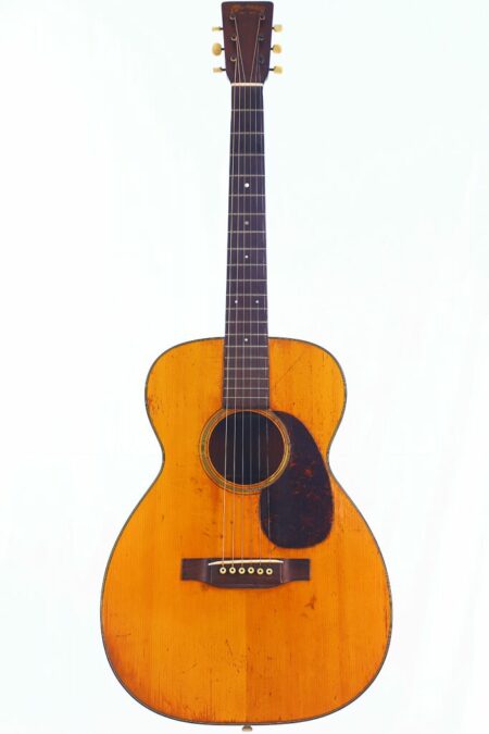A Martin 0-18 1943 Acoustic Guitar with a natural wood finish, dark pickguard, six strings, and visible signs of wear, photographed against a plain white background.