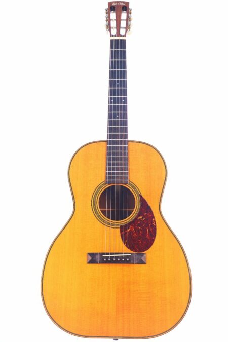 The Huss & Dalton 000-SP Custom Acoustic Guitar features a natural wood finish, six strings, and a tortoiseshell-style pickguard, shown against a white background.