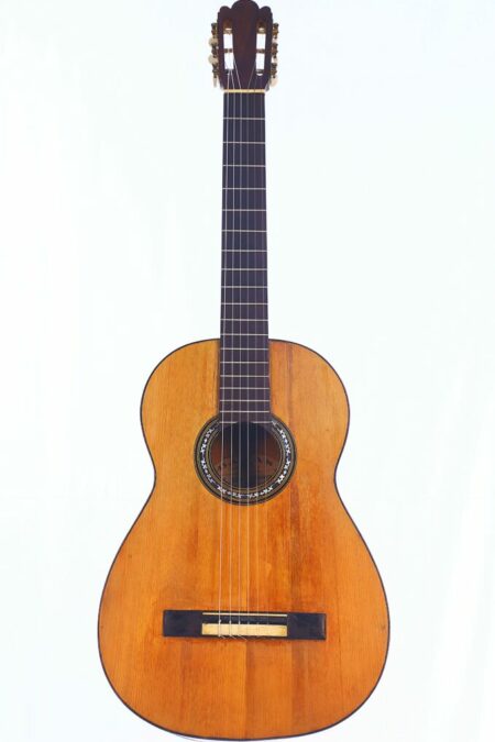 A Manuel de Soto y Solares 1900 Classical Guitar with a wooden body, six strings, and dark fingerboard, shown against a plain white background.