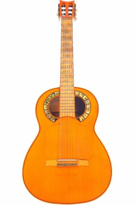 The Andalusian 1929 Simplicio Flamenco Guitar features a bright orange finish and a decorative circular pattern around the sound hole, shown against a white background.