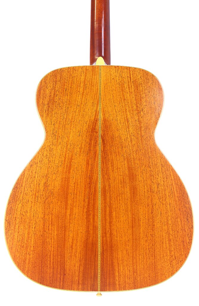The Image Shows The Back Of A Martin M-38 1979 Acoustic Guitar, Crafted From Warm, Reddish-Brown Wood With A Visible Grain Pattern And A Thin Vertical Inlay Down The Center.